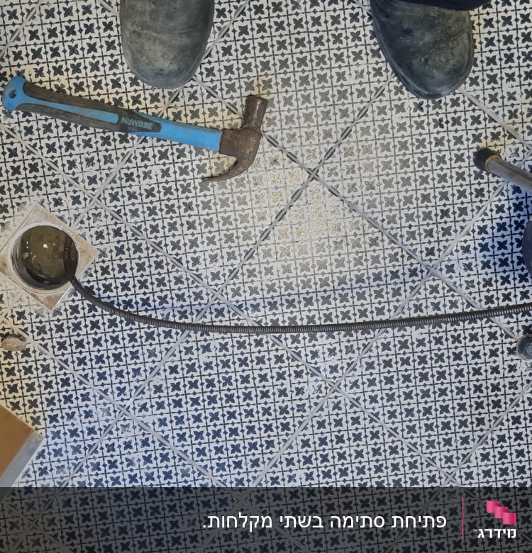 כלי עבודה של אינסטלטור על רצפה עם אריחים